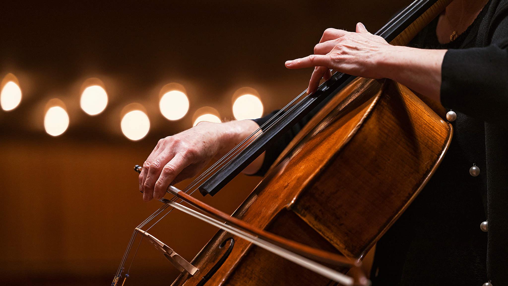Närbild på en cellist som spelar på en cello