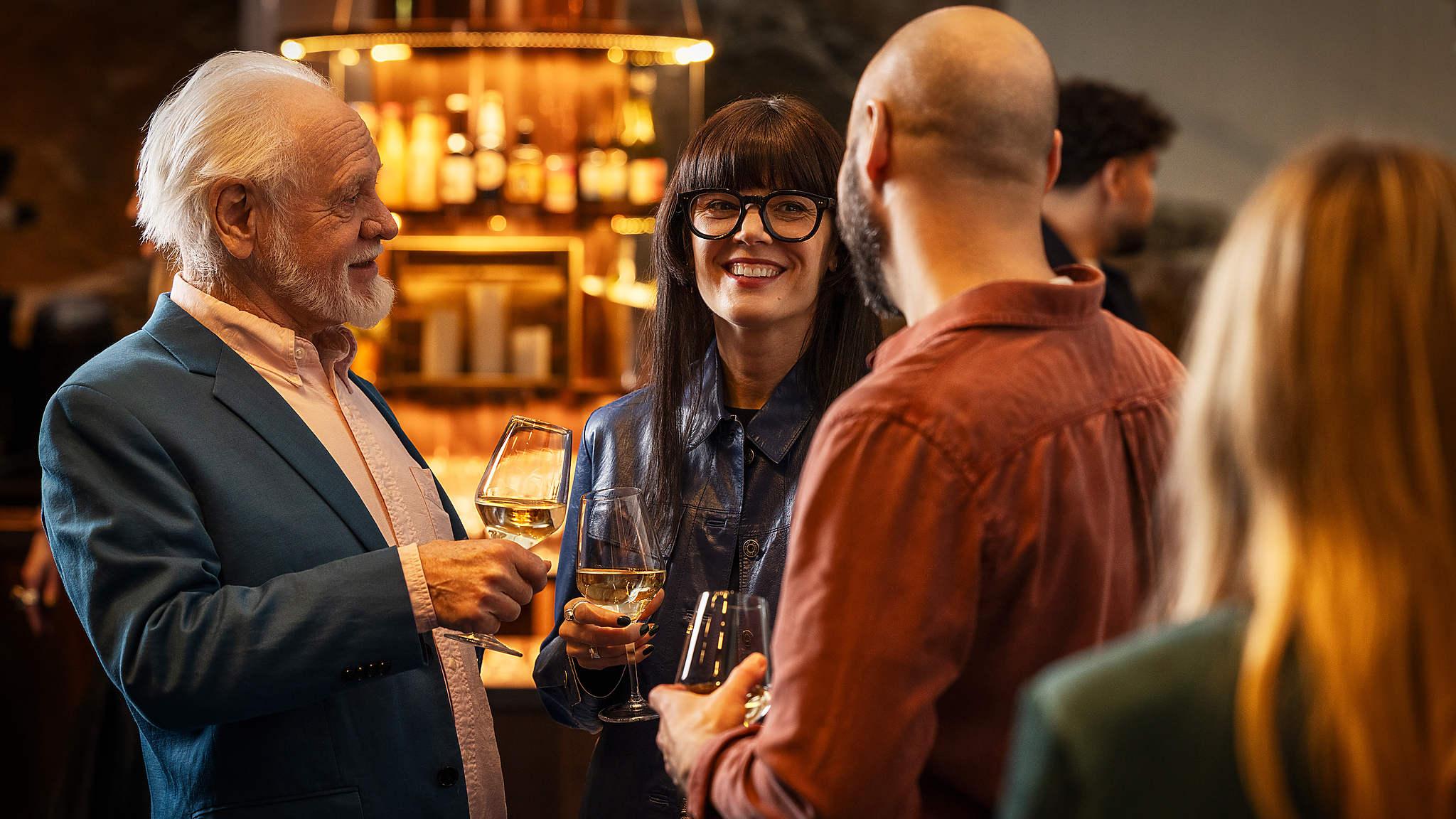 Människor skrattar och samtalar i baren i foajén i Berwaldhallen
