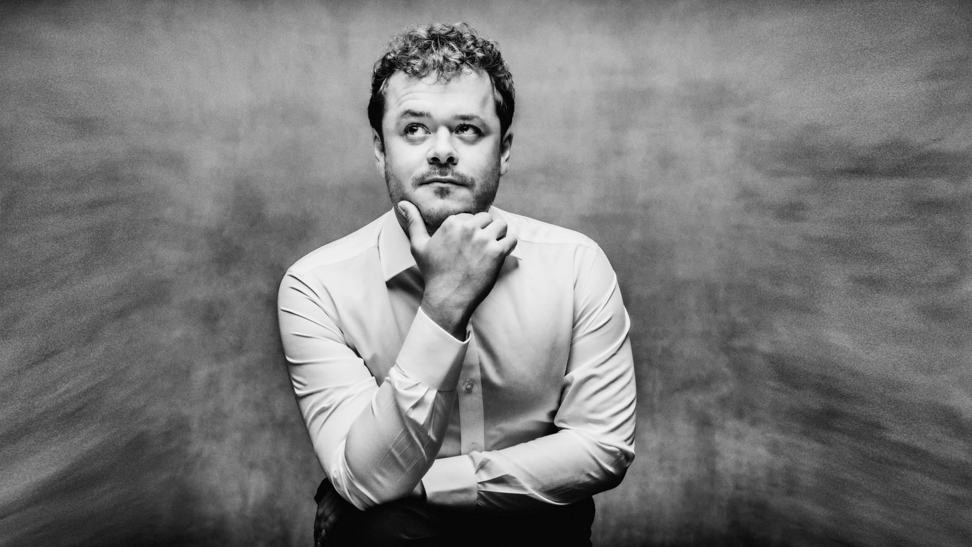 Benjamin Grosvenor, med huvudet lutat i sin ena hand och blickar åt sidan.