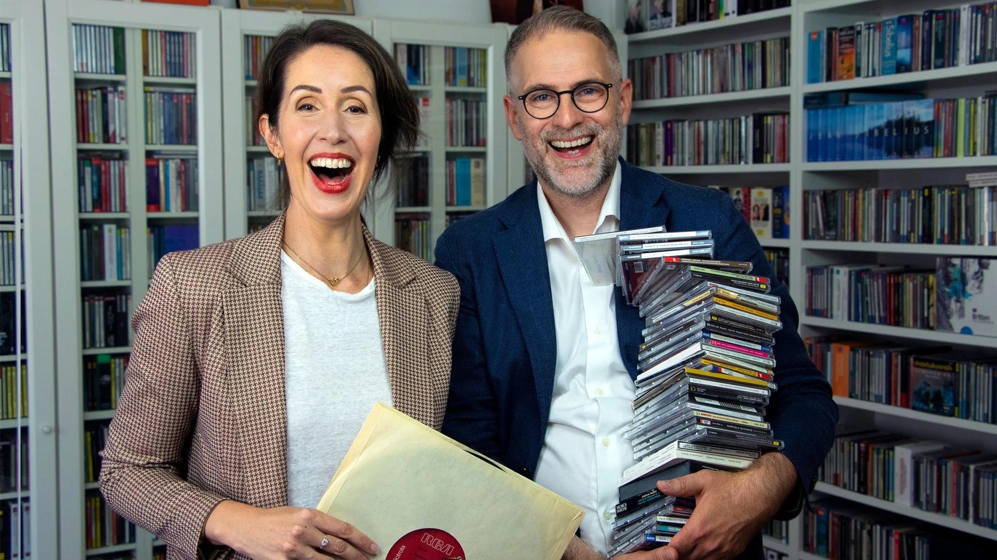 Clara Törnvall och Johan Korssell med skivor i famnen. Hon med en LP-skiva och han med en trave CD-skivor.