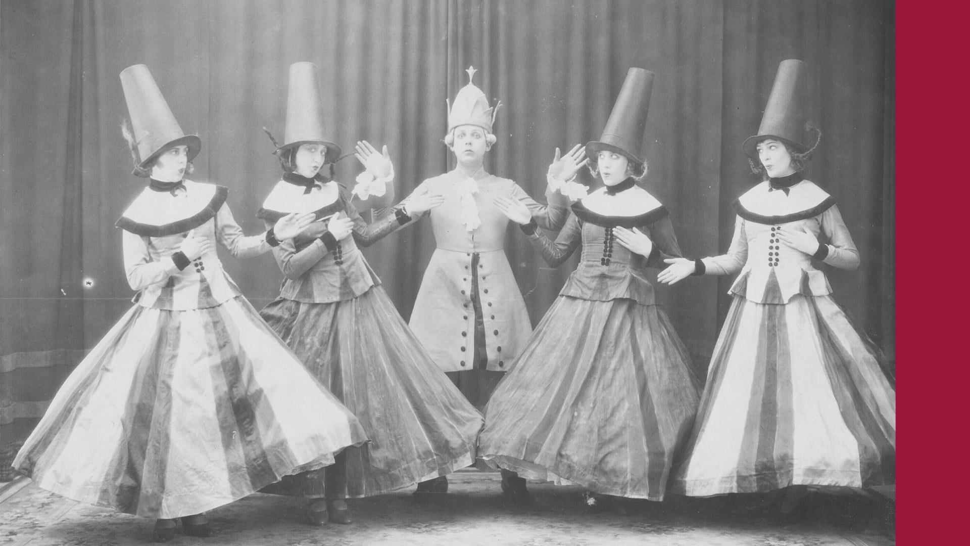 Ett svartvitt fotografi av fem dansare från Svenska Baletten i Paris under 1920-talet, i uppsättningen "De fåvitska jungfrurna". Till höger ligger ett tjockt streck i hallonrött.